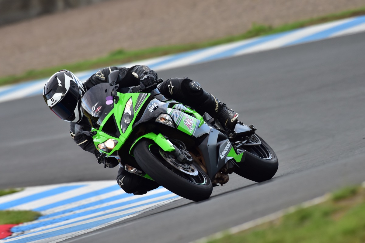 Motorbike racer leaning into a corner on a track